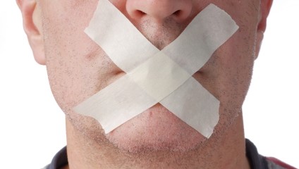 Man's mouth covered with tape in an "X" representing online reputation