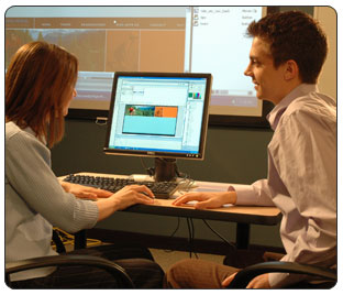 man and woman having a conversation at computer keyboard while training in social media for business