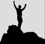 Silhouette of a man holding his arms up in victory on top of rocks
